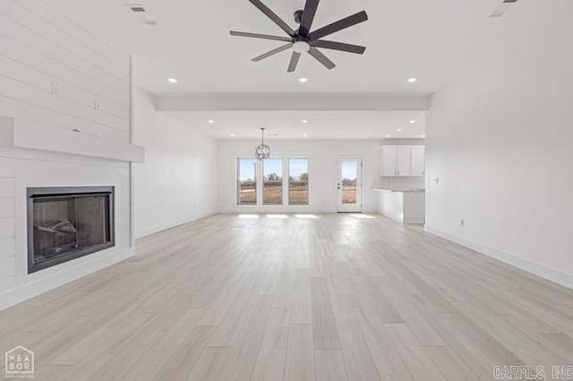 unfurnished living room featuring ceiling fan and light hardwood / wood-style flooring