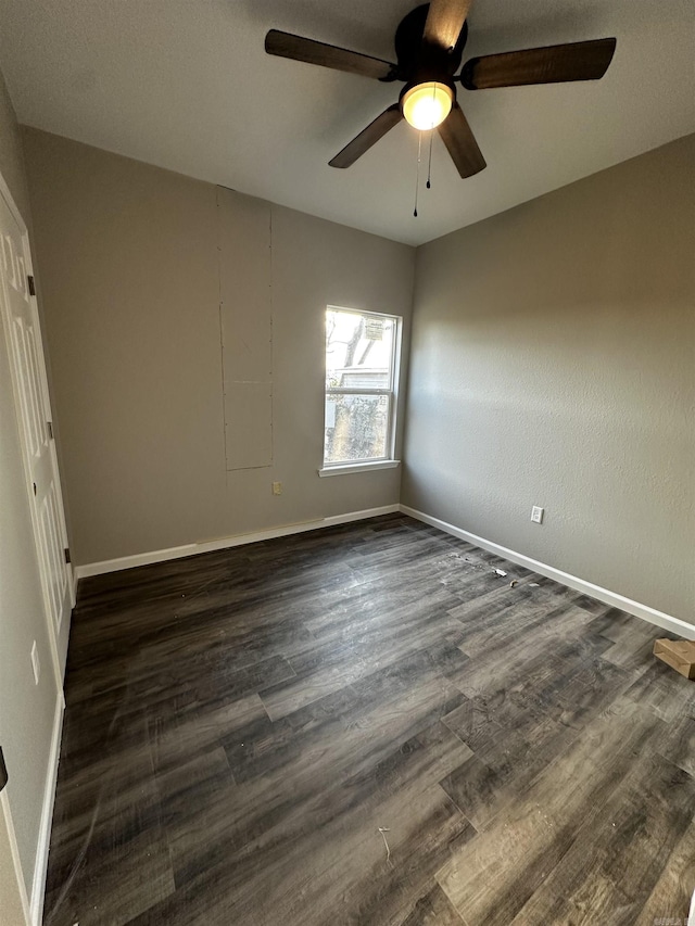 spare room with dark hardwood / wood-style flooring and ceiling fan