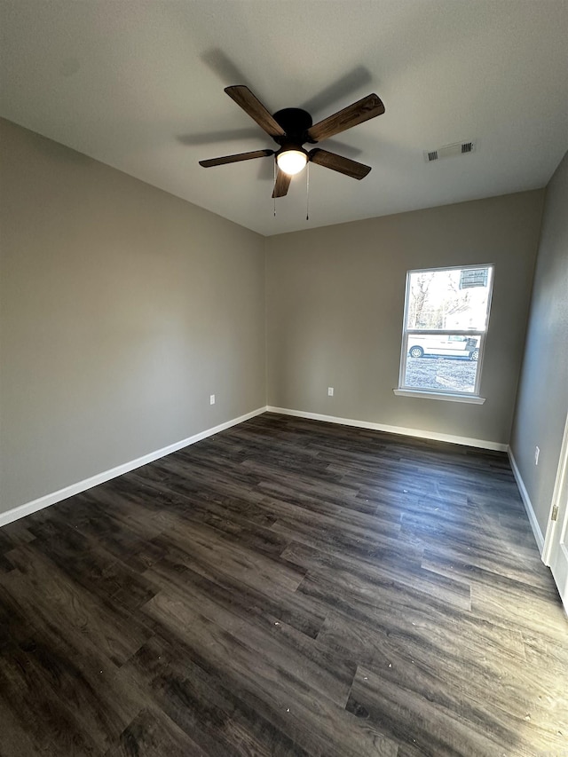 spare room featuring dark wood-type flooring and ceiling fan