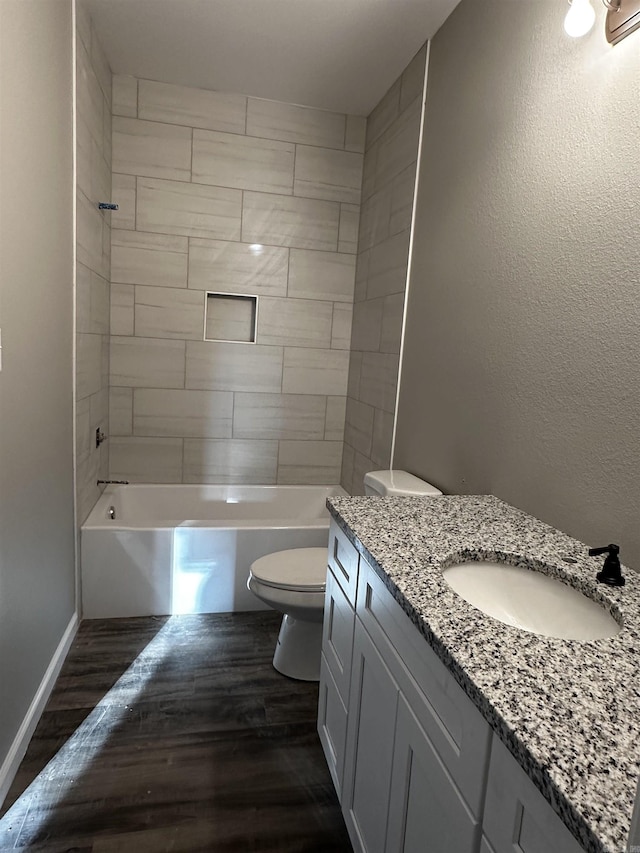 full bathroom with vanity, wood-type flooring, tiled shower / bath, and toilet