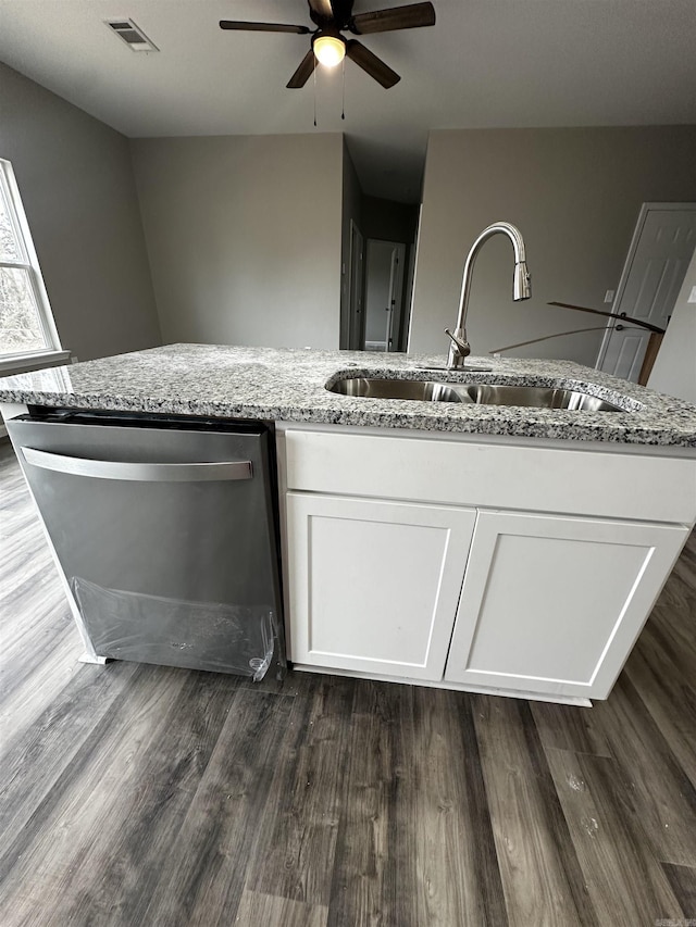 kitchen featuring light stone countertops, sink, stainless steel dishwasher, and white cabinets