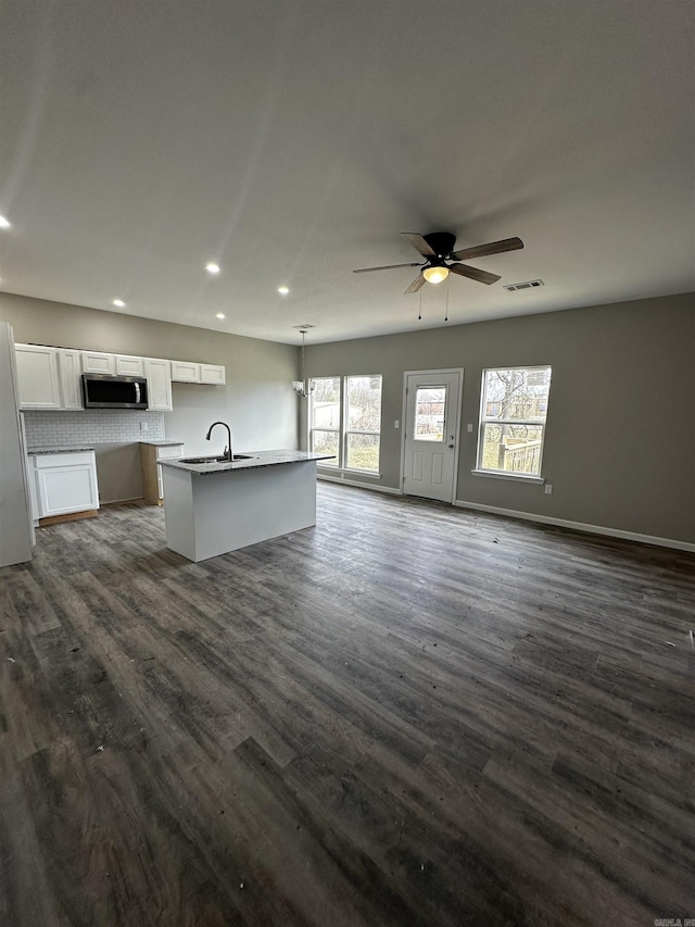 kitchen with white cabinetry, a center island with sink, white fridge, pendant lighting, and ceiling fan