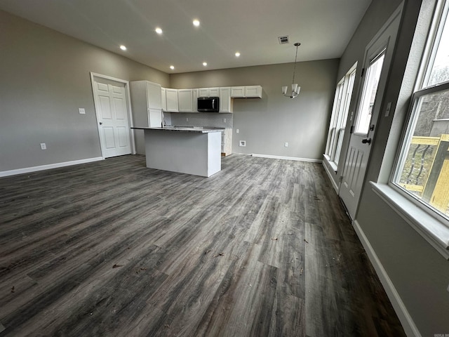 kitchen featuring a center island, dark hardwood / wood-style flooring, white cabinets, pendant lighting, and backsplash