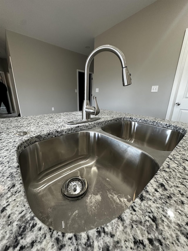 room details with light stone countertops and sink