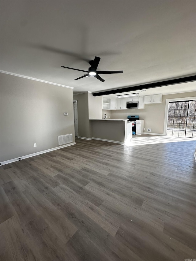 unfurnished living room with ceiling fan, crown molding, and dark wood-type flooring