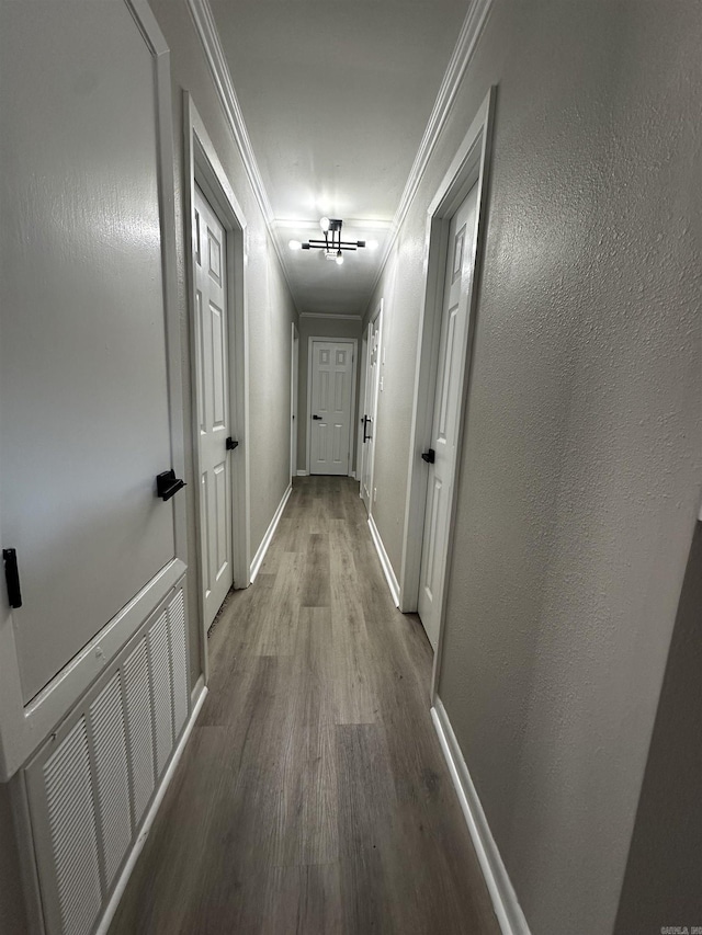 corridor with hardwood / wood-style flooring and ornamental molding