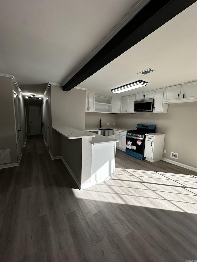 kitchen with white cabinets, black gas range oven, kitchen peninsula, and hardwood / wood-style floors