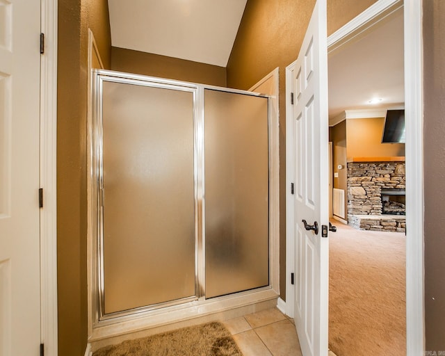 bathroom featuring a fireplace, tile patterned floors, an enclosed shower, and lofted ceiling