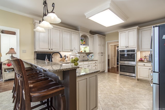 kitchen featuring decorative backsplash, appliances with stainless steel finishes, kitchen peninsula, light stone counters, and decorative light fixtures