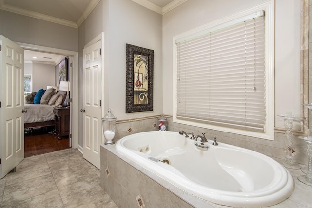 bathroom with ornamental molding and tiled tub