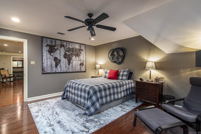 bedroom with dark hardwood / wood-style floors, ceiling fan, and ornamental molding