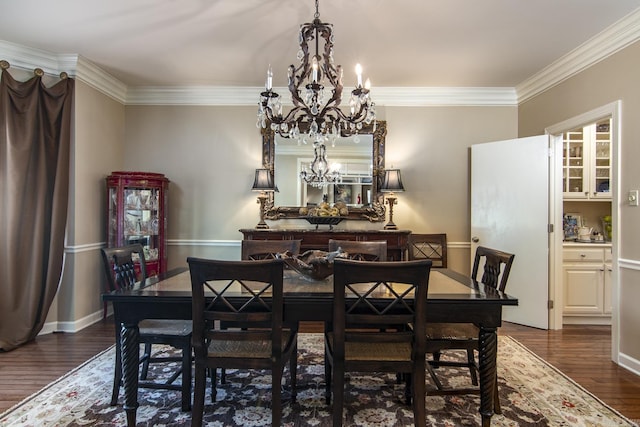 dining area featuring dark hardwood / wood-style flooring, crown molding, and an inviting chandelier