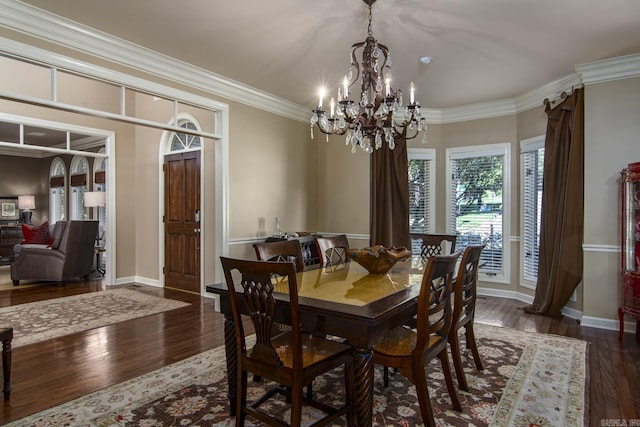 dining room featuring dark hardwood / wood-style floors, ornamental molding, and a notable chandelier