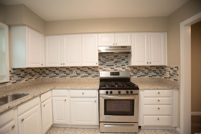 kitchen with white cabinets, stainless steel gas stove, and decorative backsplash