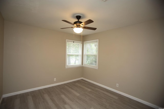 spare room with ceiling fan and dark hardwood / wood-style flooring