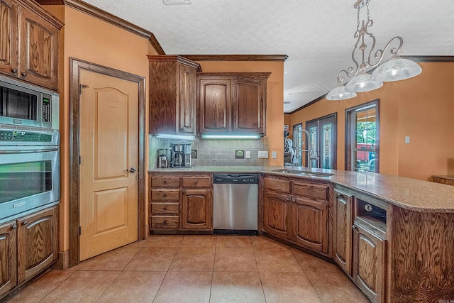 kitchen with kitchen peninsula, appliances with stainless steel finishes, backsplash, ornamental molding, and sink