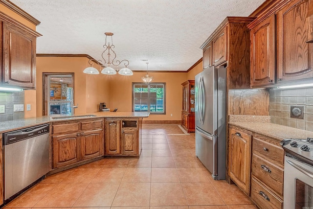 kitchen with sink, hanging light fixtures, kitchen peninsula, decorative backsplash, and appliances with stainless steel finishes