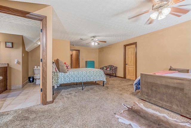 carpeted bedroom featuring ceiling fan, ensuite bathroom, and a textured ceiling