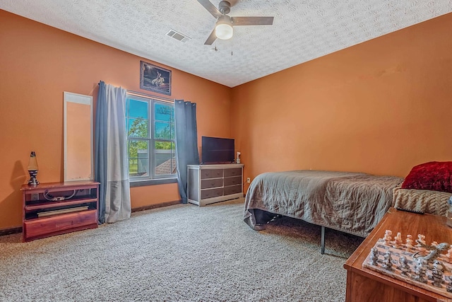 carpeted bedroom with a textured ceiling and ceiling fan