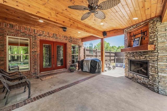 view of patio / terrace with area for grilling, ceiling fan, french doors, and an outdoor stone fireplace