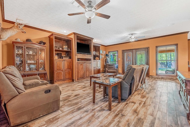 living room featuring light hardwood / wood-style floors, a textured ceiling, and ornamental molding