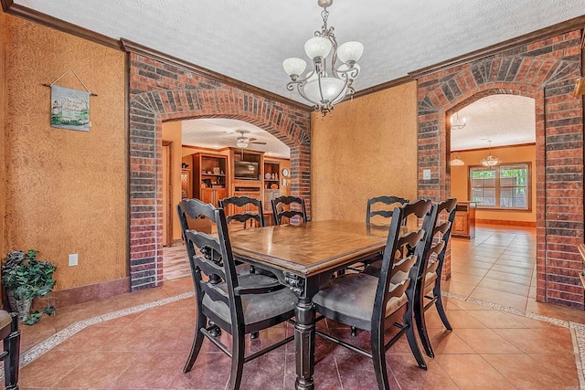 tiled dining area with a textured ceiling, crown molding, and ceiling fan with notable chandelier