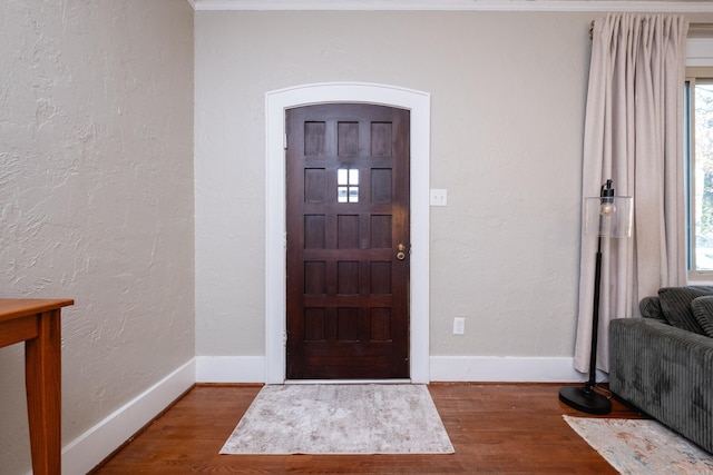 foyer with crown molding and hardwood / wood-style floors