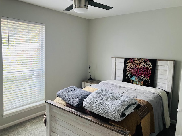 bedroom with ceiling fan, carpet floors, and multiple windows