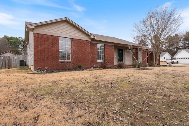 ranch-style house featuring a front lawn and central air condition unit