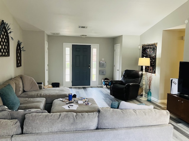 living room with light hardwood / wood-style flooring and lofted ceiling