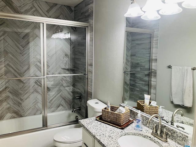 full bathroom featuring vanity, bath / shower combo with glass door, and toilet