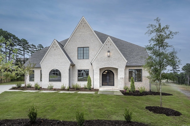 french provincial home featuring french doors and a front lawn