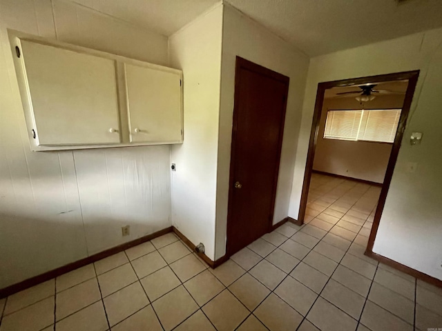 laundry room featuring ceiling fan and light tile patterned floors