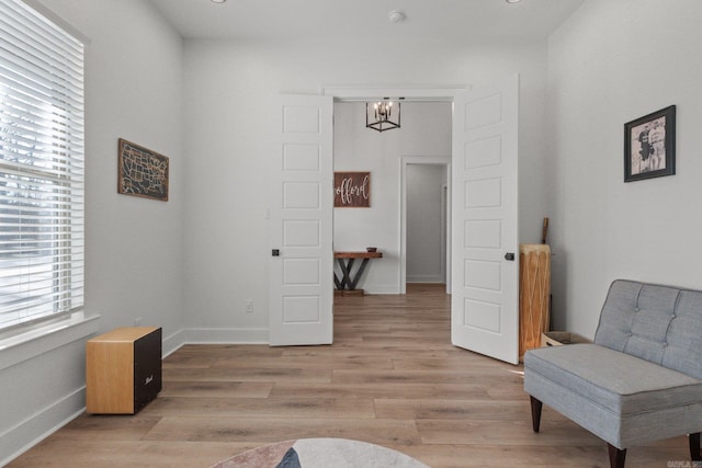 living area featuring light hardwood / wood-style flooring and an inviting chandelier