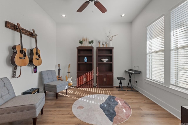 living area featuring ceiling fan and light hardwood / wood-style flooring