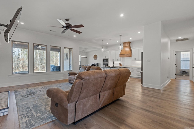 living room with ceiling fan and light hardwood / wood-style flooring