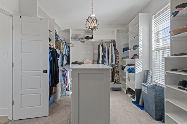 spacious closet featuring light carpet and an inviting chandelier