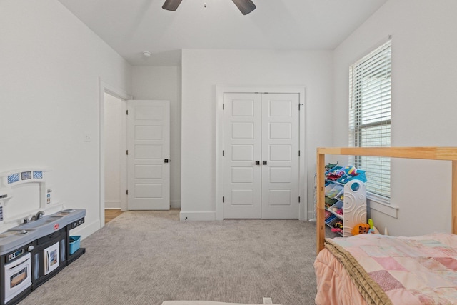 carpeted bedroom with ceiling fan and a closet