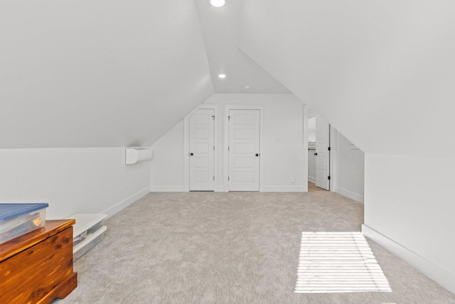 bonus room featuring lofted ceiling and light carpet