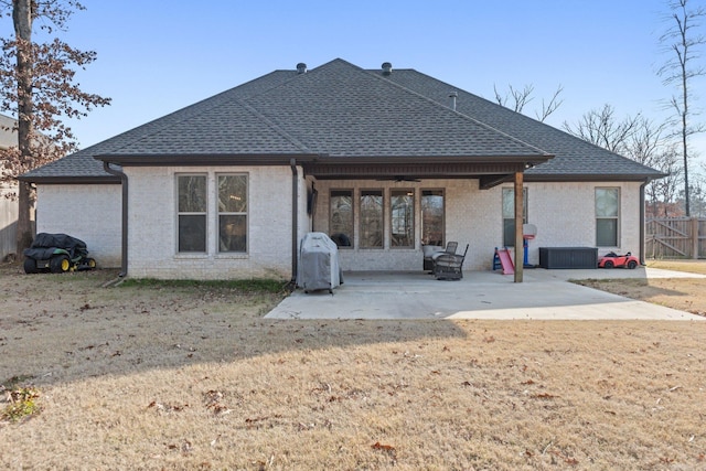 rear view of property with a yard, cooling unit, and a patio area