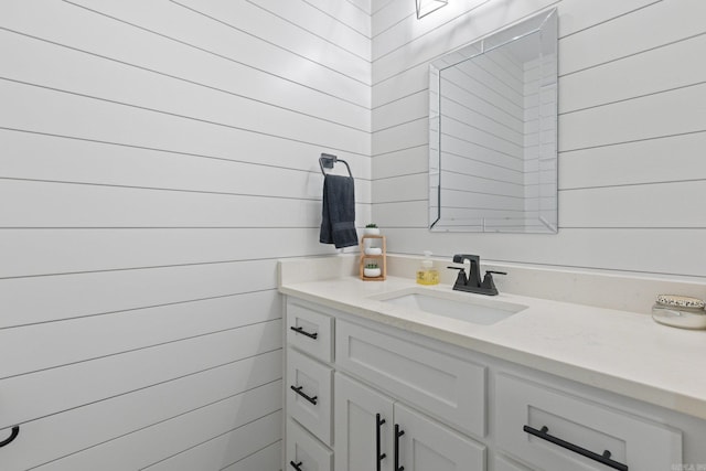 bathroom with vanity and wooden walls