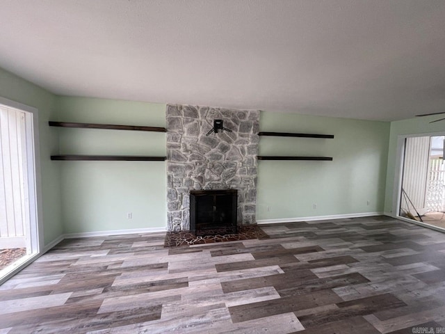 unfurnished living room featuring ceiling fan, a fireplace, and hardwood / wood-style flooring