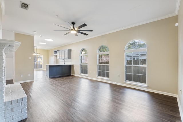 unfurnished living room featuring dark hardwood / wood-style flooring, a brick fireplace, ceiling fan, and crown molding