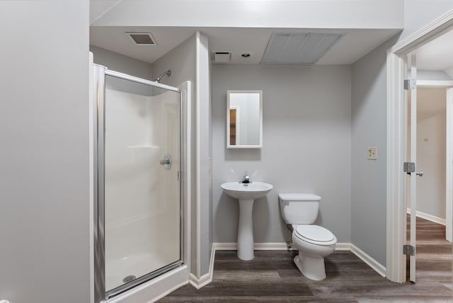 bathroom with hardwood / wood-style floors, toilet, and walk in shower