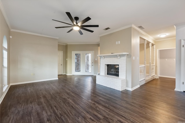 unfurnished living room with dark wood-type flooring, a brick fireplace, ceiling fan, and ornamental molding