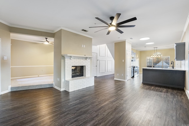 unfurnished living room featuring a brick fireplace, ceiling fan, sink, and ornamental molding