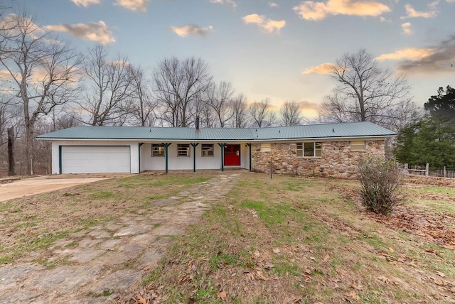 ranch-style home with a garage and a yard