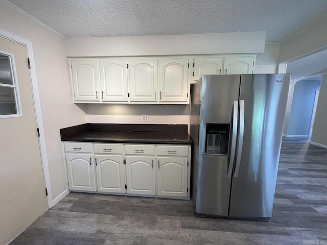 kitchen featuring stainless steel fridge, dark hardwood / wood-style flooring, white cabinets, and a textured ceiling