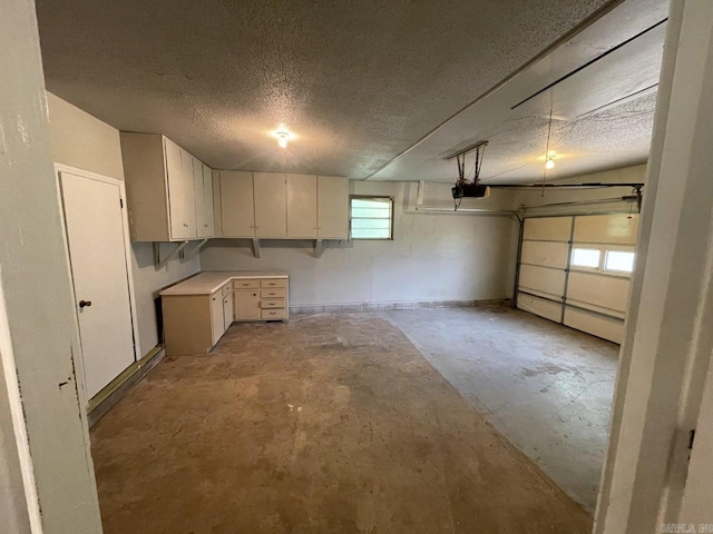 garage with a garage door opener and a baseboard heating unit