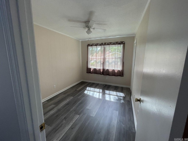 unfurnished room featuring a textured ceiling, dark hardwood / wood-style floors, ceiling fan, and ornamental molding